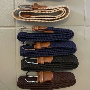 Flätat bälte med läderdetaljer och metallspänne - Snyggt flätat bälte med bruna läderdetaljer och silverfärgat metallspänne. Finns i beige, svart, marinblå och mörkbrun färg. Perfekt accessoar för att lyfta din outfit.