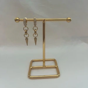 Silverfärgade örhängen med kedjor och spetsiga hängen - Säljer ett par trendiga örhängen i silverfärg med glittriga stenar på ringen, kedjedetaljer och spetsiga hängen. Perfekta för att ge din look en edgy touch. Snygga och moderna accessoarer!