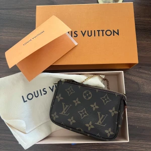 Louis Vuitton mini pochette - Säljer denna fina LV mini pochette i väldigt fint skick! Det enda är att guldpläteringen har försvunnit lite på ena sidan (se bild). Kvitto, dustbag och låda följer med i köpet. Skriv gärna vid mer frågor! ☺️kan gå ner i pris vid snabb affär! Mått: 15,5x10,5x4cm