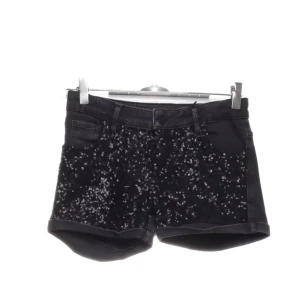  Jeans shorts  - Snygga svarta shorts från Vingino Jeans med glittriga paljetter på framsidan. Klassisk femficksmodell med knapp och dragkedja. .