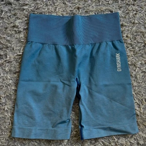 Blå träningstights shorts från Gymshark - Säljer ett par blå träningstights shorts från Gymshark med hög ribbad midja. Perfekta för gymmet eller annan träning. Stretchigt material som sitter skönt och följsamt💙