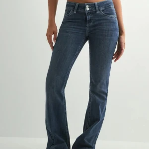 Blå bootcut jeans med kontrastsömmar - Snygga blå bootcut jeans Jeansen har låg midja och stängs med dragkedja och två knappar. Perfekta för en avslappnad och trendig look. Så sköna och stretchiga. Mycket bra skick! hör av er vid frågor🥰