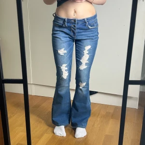 Jeans med hål - Sypersnygga Jeans med hål. Nyskick. Storlek w28. Modell mid rise flip-flop flare. Innerbenslängd: 80 midjemått: 38 stretch till 43. Köp sker via köp nu, jag postar inom 24h. Kvar tills markerad såld 