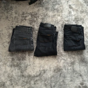 3 par svarta och gråa jeansbyxor från Nudie Jeans - Tre par smala jeansbyxor från Nudie Jeans i olika nyanser av svart och grått. Alla har klassisk femficksdesign. Pris kan diskuteras