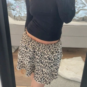 Leopardmönstrad kortkjol - Säljer en snygg kortkjol med leopardmönster. Kjolen har en lös passform och resår i midjan för extra komfort. Perfekt för dig som vill sticka ut med ett trendigt djurmönster. Hittar ingen artikel!