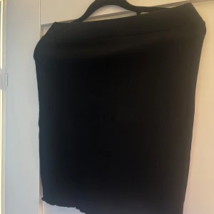 Svart kjol från XOXO friends - Enkel svart kjol från XOXO friends. Kjolen har rak passform och är tillverkad i ett mjukt tyg som faller snyggt. Perfekt att matcha med olika toppar för en stilren look.