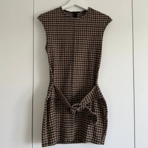 Klänning med bälte, Zara - Super snygg och söt, rutig klänning med bälte. Klänningen är ärmlös och har en rak, kort passform. Perfekt för dig som gillar klassiska mönster med en twist💞💞 Aldrig använd!