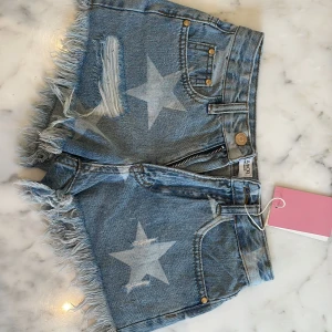 Super snygga Jeansshorts från Design by Amor - Snygga blå jeansshorts med fransig kant och slitningar i XS. De är från Design by Amor och är helt helt nya. Jag var super taggad på att få de men de var tyvärr för små och därför jag säljer de. Aldrig använda. Du får lappen och påsen de kom i. Säljer därför för original priset på 300kr.