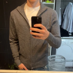 Grå merino full zip - Säljer min fina full zip från these glory days, tröjan är knappt använd och skicket är definitivt 10/10. Nypris på den här ligger på 1200