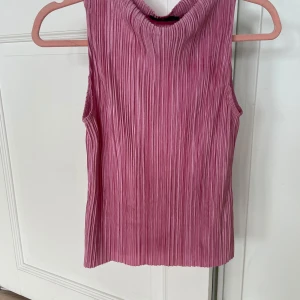 Rosa plisserad ärmlös topp - Säljer en snygg rosa ärmlös topp med plisserat tyg🩷