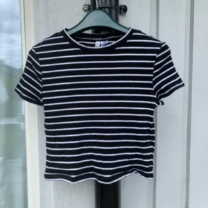Randig kort T-shirt från H&M 🤍🖤 - Super söt kort T-shirt från H&M med stretch material (Står L i lappen men motsvarar XS) ❤️ Super skönt material och mycket fint skick!