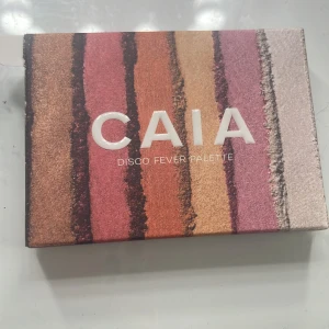 CAIA Disco Fever ögonskuggspalett - Säljer CAIA Disco Fever Palette med sex skimrande ögonskuggor i nyanser av silver, lila, guld, koppar, rosé och brons. Paletten har ett genomskinligt lock och är perfekt för att skapa glammiga och färgstarka ögonlooks. Jag säljer denna för jag inte använder ögonskugga och är typ oanvänd har använt den en gång 