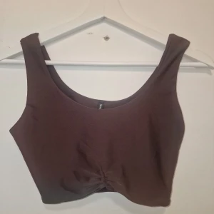 Brun croppad linnetopp - Säljer en brun croppad linnetopp. Den har en mjuk och stretchig känsla, perfekt till jeans eller kjol för en chill look.