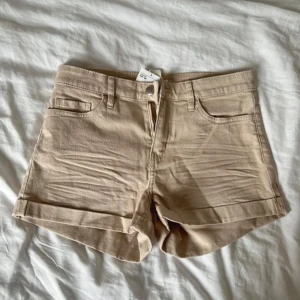 Ljusbeige jeansshorts - Snygga beige jeansshorts från H&M. Perfekta för varma dagar och enkla att matcha med allt. Shortsen är ljusare i verkligheten