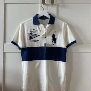 Helt ny Ralph Lauren piké - Helt ny pike från Ralph Lauren med en unik design. Tröjan har tagsen kvar och är aldrig använd. Hör  gärna av er vid frågor och funderingar!