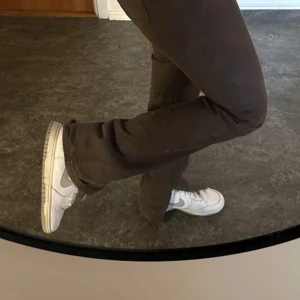 Zara Bruna bootcut byxor med slits - Säljer ett par bruna bootcut byxor med snygg slits nertill framtill. Byxorna har en rak och lite utsvängd passform och är tillverkade i ett mjukt bomullsmaterial. Perfekta för dig som gillar en avslappnad men trendig look.