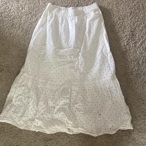 Vit långkjol med broderade detaljer - Superfin vit långkjol med broderade hålmönster och volang nertill.