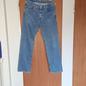 Blå jeans från MC Gordon Classic Fit - Klassiska blå jeans från MC Gordon i rak modell. Jeansen är tillverkade i 100% bomull med ring spun denim och har fem fickor samt gylf med dragkedja och knapp. Perfekta för en avslappnad och tidlös look.