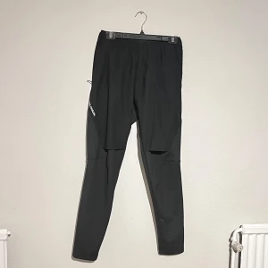 Träningsbyxor - Träningsbyxor från Salomon i storlek S. Använda endast ett fåtal gånger. Ventilering bak vid rumpan och fram på låren. Fickor med dragkedja finns, samt snörning. 