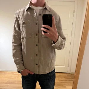 Dobber Overshirt beige  - Säljer denna sjukt snygga Overshirten från Dobber⭐️ Färgen är beige och storleken är M✅ Overshirten har inga defekter och skicket är utomordentligt🙌🤝 Sjukt najs passform och passar perfekt till hösten🍁🙌 Tveka inte på att höra av er dig vid minsta fråga eller fundering😊