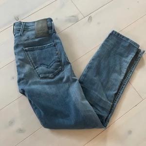 Replay Hyperflex blå jeans - Säljer ett par blå Replay Hyperflex jeans med klassisk femficksdesign och snygga slitningar framtill. Storlek 28W 30L. Nyskick, hör av dig ifall du har några funderingar!