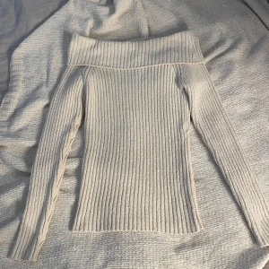 Beige ribbad stickad tröja Lindex - Superfin beige stickad tröja från Lindex i storlek S. Tröjan har bred offshoulder-krage och är ribbstickad för en snygg och bekväm passform. Perfekt till höst och vinter när du vill vara både varm och stilren.