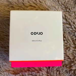 Odejo Eau de Toilette 100ml - Odejo Eau de Toilette i en stilren, fyrkantig glasflaska med silverfärgad spraykork. Kommer i en vit kartong med neonrosa och neongröna detaljer. Flaskan rymmer 100ml och är tillverkad i Storbritannien. Perfekt för dig som gillar minimalistisk design och färgstarka inslag. Nypris 1200:- ca . Toppnpt; lilja, gurka
