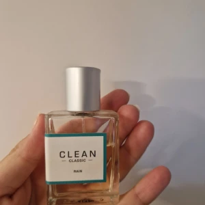 CLEAN Classic Rain parfym - Fräsch parfym från CLEAN Classic i doften Rain. Flaskan är rektangulär i genomskinligt glas med en stilren vit etikett och blå kant. Locket är i matt silverfärgad metall. Perfekt för dig som gillar lätta, rena dofter. Ca 1/4 av parfymen är använd men jag passar inte riktigt i doften. Ca 450kr i nypris. 