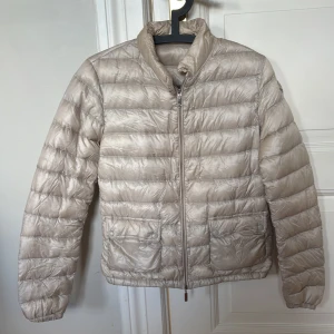 Beige dunjacka från Moncler, modell Lans  - Beige dunjacka från Moncler, strl 1. Modell:Lans. Använd men har mer att ge- inga defekter