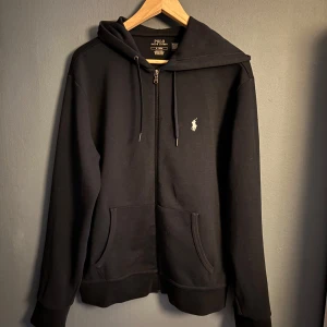 Polo Ralph Lauren Zip Hoodie - Tja, säljer nu denna snygga Polo Ralph Lauren Zip Hoodie i storlek M. Endast antal ett fåtal gånger så den är i ett gott skick!! QR-kod finns, se bild 2. Hör av er vid frågor eller funderingar                             OBS!!!!! 100% äkta