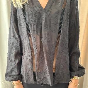 Svart blus med broderi från Levete Room - Svart blus från Levete Room med v-ringning, super snygg både till fest och till vardags!!🤩🤩