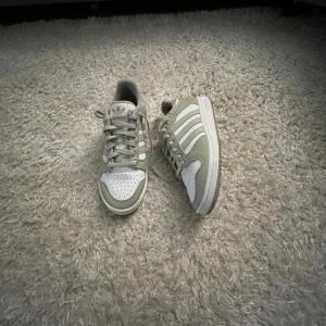 Adidas Forum Low sneakers i vitt och beige - Snygga Adidas Forum Low sneakers i vitt och beige med klassiska tre ränder på sidan. Skorna har snörning, perforerad tå och låg profil. Tillverkade i skinn och syntet för en clean och sportig look. Perfekta för dig som gillar retrovibbar och streetstyle.