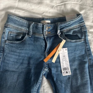 Blå jeans från Gina Tricot - Snygga blå jeans med låg midja och flare-ben från Gina Tricot Young. Jeansen är i storlek 152 och aldrig använda då de ej passade!