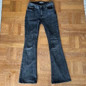 Gråa bootcut jeans Gina tricot - Snygga gråa jeans med bootcut-ben i storlek 36. Jeansen ser ut att vara medelhöga i midjan men jag skulle säga att dem är lågmidjade på. 