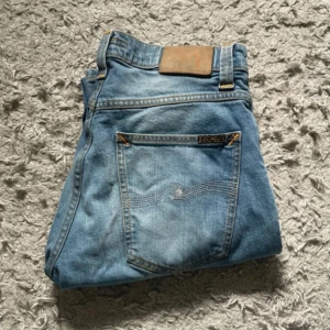 Nudie Jeans 31/32 - Blåa nuide jeans i stolek 31W 32L i modellen grim tim. Knappt använda och jättebra kvalitet, säljer då de är för små. Helt okej att skriva vid minsta fråga.