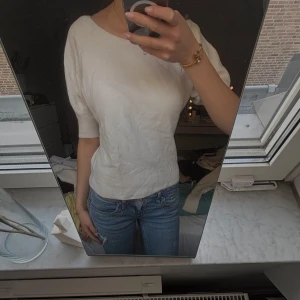 Vit kortärmad topp - Säljer en enkel och stilren vit topp med korta ärmar och rund halsringning. Perfekt att matcha med jeans eller kjol för en clean look.