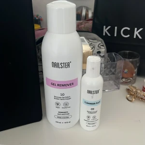 Nailster Gel Remover och Cleanser Plus - Två flaskor från Nailster: en stor vit flaska Gel Remover (570 ml) med lila etikett och en mindre vit flaska Cleanser Plus (100 ml) med blå etikett. Perfekt för borttagning av gelnagellack och rengöring av nagelytan. 150 kr flr båda.