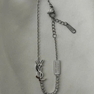 YSL halsband i silver med strassdetaljer - Två ysl halsband en i guld och en i silver 