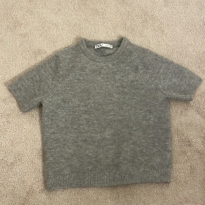 Grå stickad kortärmad tröja från Zara - Mysig grå stickad tröja från Zara med korta ärmar och rund halsringning. Använder inte längre. Pris kan diskuteras.💕kom privat för bilder💕