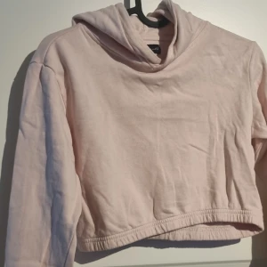 Ljusrosa croppad hoodie från XOXO friends - Säljer en ljusrosa croppad hoodie från XOXO friends. Tröjan har långa ärmar och en kortare midjelängd,  mysig huva. 