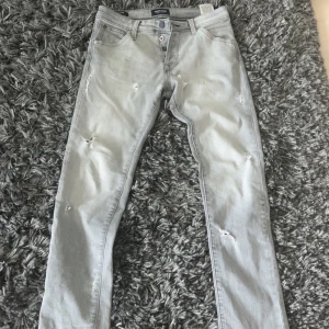Ljusgrå jeans från Jack & Jones - Säljer ett par riktigt feta jeans från Jack and Jones med slitningar. Skriv om du har några frågor eller funderingar!