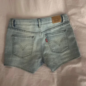 Jeansshorts  - Säljer ett par lågmidjade jeansshorts från Levi's. De är i storlek 140cm, skulle säga de motsvarar xxxs. Aldrig använda så precis som nya.