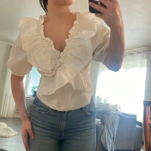 Vit Zara blus med volang och puffärm❤️ - Säljer en söt vit blus med stora volanger längs ringningen och puffiga korta ärmar. Supersnygg😁 Slutsåld