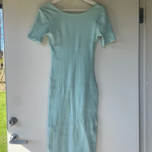 Ljusblå ribbad långklänning från Gina Tricot - Supersnygg ljusblå ribbad långklänning från Gina Tricot. Klänningen har korta ärmar, rund halsringning fram och djupare rygg. Perfekt för vår och sommar, enkel att styla med sneakers eller sandaler.