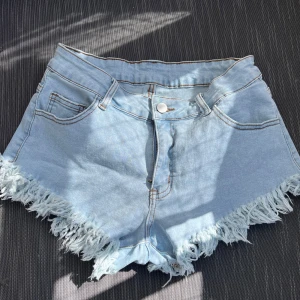 Shorts med fransar - Korta jeansshorts med fransar nertill, skulle säga mellan mid och hög i midjan 🫶🏻 Köptes till temafest men kom aldrig till användning 🩵