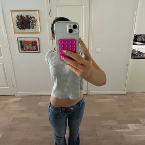 Ljusgrön croppad topp med knyt i ryggen - Trendig ljusgrön croppad topp med korta ärmar och två knytband i ryggen. Toppen har en lätt ribbad struktur och är perfekt för en avslappnad stil. Passar snyggt till jeans eller kjol. Finns en knapp där bak som inte var knäppt på bilden❤️ skriv för fler bilder!