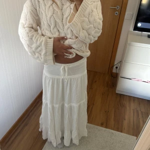 Vit långkjol med knyt - Superfin vit långkjol med volanger och knyt i midjan. Aldrig använd