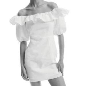 Vit offshoulder kortklänning med volang - Superfin vit kortklänning i linne med offshoulder och puffärmar. Klänningen har en bred volang runt axlarna som ger en romantisk vibe. 💘💘