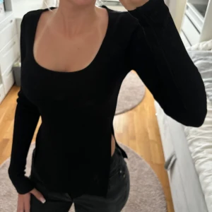 Ribbad topp med slits - Svart ribbad topp med slits på sidorna