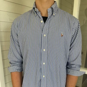 Ralph lauren skjorta  - Säljer denna riktigt snygga randiga Ralph lauren skjorta i vitt och blått, den är i mycket bra skick förutom den fläcken som syns på sista bilden, storlek M men sitter mer som L då den är 80 cm lång och 57 cm bred under armhålorna, kolla gärna min Vinted om ni vill se bättre bilder heter axelbli08 där, hör gärna av dig vid frågor!